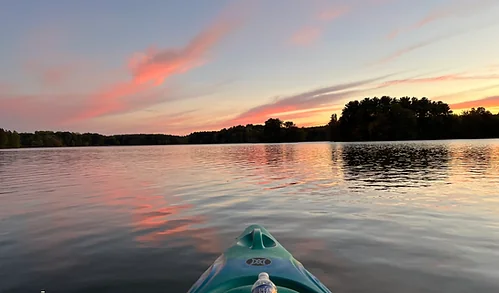 Kayak bow on the calm waters of Mogadore Reservoir at sunset