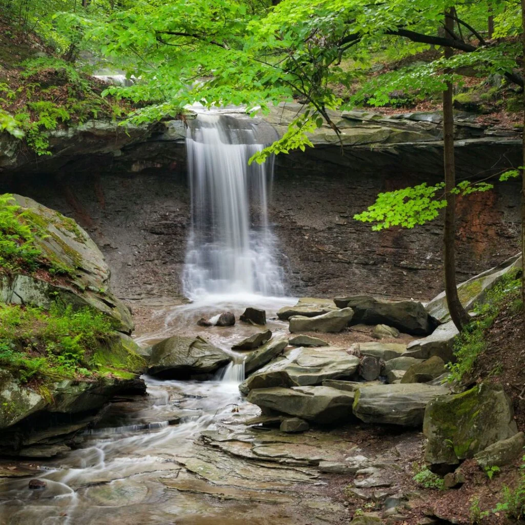 A 60-foot waterfall cascades through the lush green forest of Cuyahoga Valley National Park